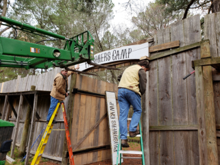 Volunteers hang Camp Entrance sign